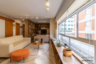 Apartamento super reformado na Itacolomi: 109 m2, 2 dormitórios e uma suíte, living espaçoso integrado à cozinha, escritório e 1 vaga. Vamos começar pela localização: Morar na parte de alta de Higienópolis, tem muitas vantagens. Além de ser uma região mais tranquila, tem um bônus: a vizinhança. Já imaginou ser vizinho do Fabrique, da Mercearia do Francês e da Dulca? Uma tentação, né? Esse apartamento garante esse privilégio. Também é importante dizer que existe uma feira a poucos passos do prédio, mas não na mesma rua, permitindo a entrada e saída de carros. Falando em mobilidade, vale ressaltar que o apartamento conta com uma vaga e fica apenas alguns minutos de caminhada da Estação Higienópolis - Mackenzie do metrô. Agora vamos ao apartamento! Começando pela reforma, recente e super cuidadosa. Além da básica renovação das instalações hidráulicas e elétricas, a obra incluiu a marcenaria, em todos os ambientes. A planta é super flexível, permitiu integrar os espaços e converter os antigos espaços de serviço em ambientes sociais. A primeira mudança foi a integração da cozinha com o living, assim como a abertura do terceiro dormitório, transformado em sala de TV. O antigo dormitório de serviço deu lugar a um escritório totalmente privativo, localizado no coração do apartamento. Hoje ele conta com dois dormitórios, sendo uma suíte e mais um banheiro social completo, que também pode servir como lavabo. Outro destaque do apartamento é o imenso janelão que percorre toda a extensão da parede da sala de estar. Esse elemento arquitetônico foi enaltecido com a abertura da cozinha, pois além de trazer mais iluminação natural, ainda garante ventilação cruzada. Para finalizar, é importante mencionar que o prédio é bem mantido, tem apenas dois apartamentos por andar e passou por uma manutenção recente da fachada.